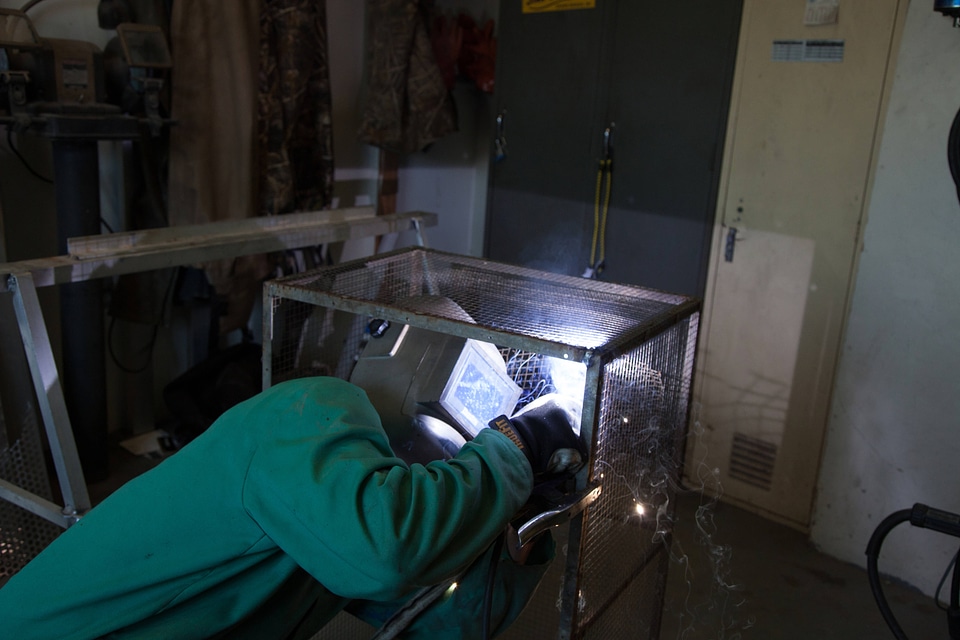 Service employee welds cages-1