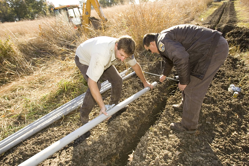 U.S. Fish and Wildlife Service employees laying pipe