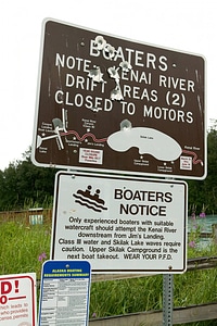 Signs with boating regulations and a Kenai River map photo
