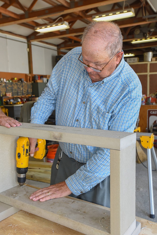 Volunteer works on wood project in shop