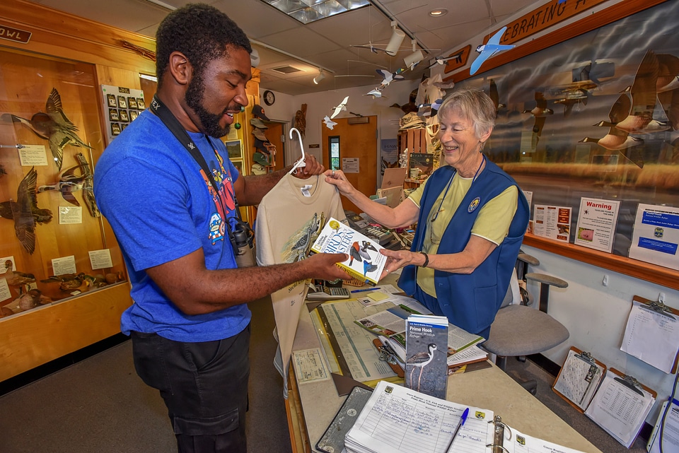 FWS volunteer with visitor in gift shop-1