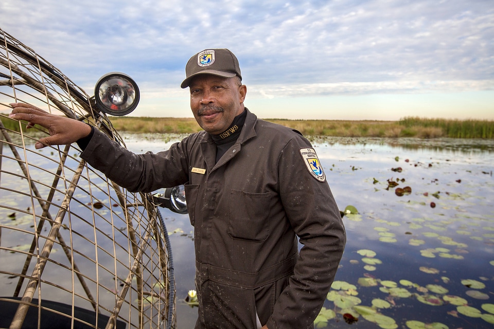 Employee leans on a docked airboat
