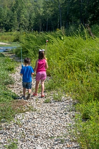 Little boy and girl going fishing, walking along creek-2