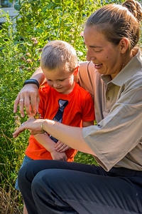 Child and fws employee look at monarch