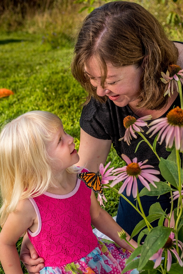 Mother and daughter with monarch on flower