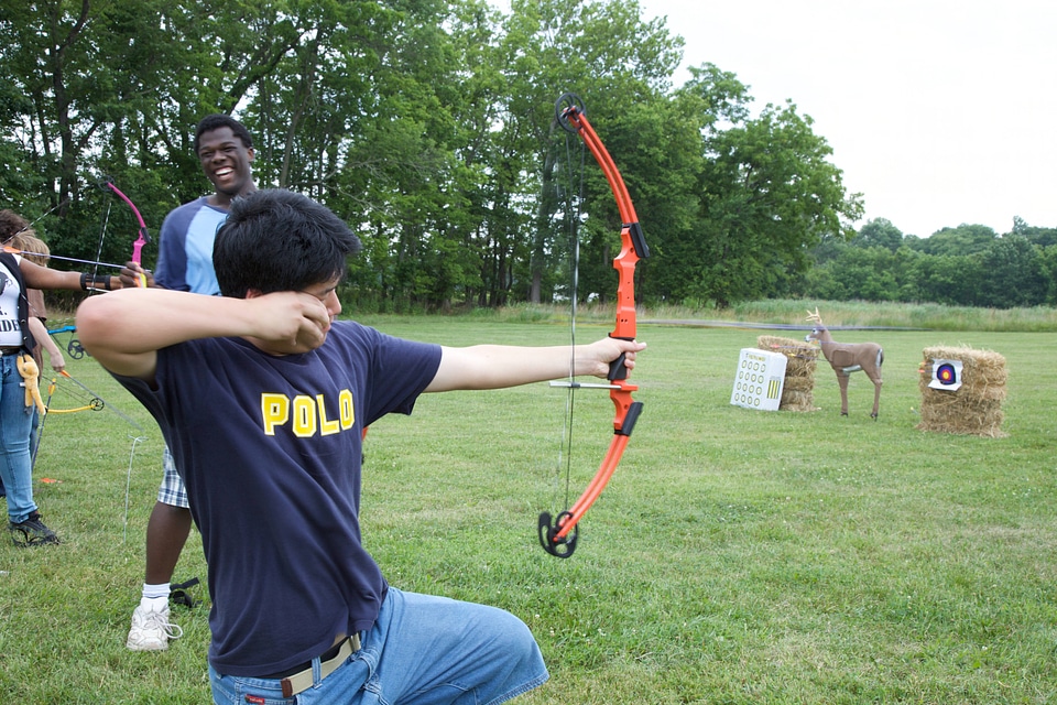 Young man learning bow and arrow skills
