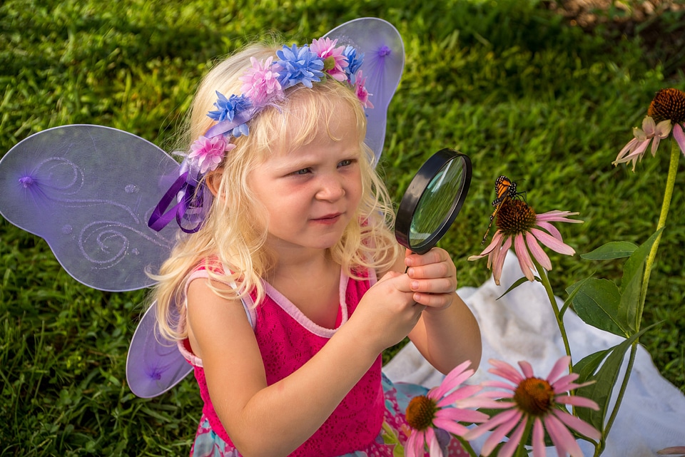 Little girl looks at monarch through eye glass-2