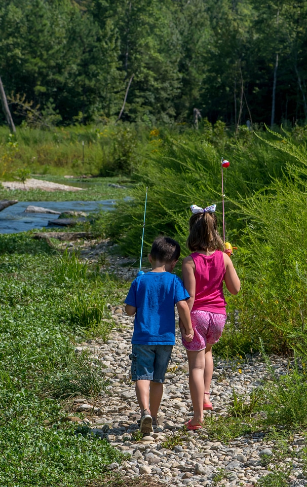 Little boy and girl going fishing, walking along creek-3