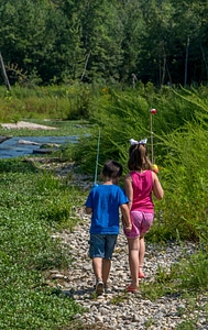 Little boy and girl going fishing, walking along creek-3