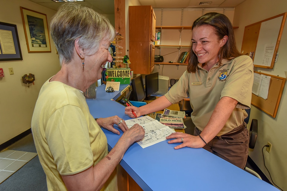 FWS Staffer greets visitor at visitor center desk-4