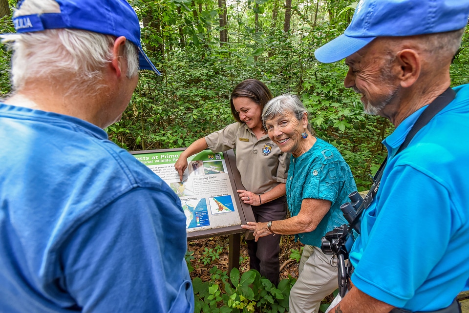 FWS Visitor services staffer shows interpretive panel to visitors-3