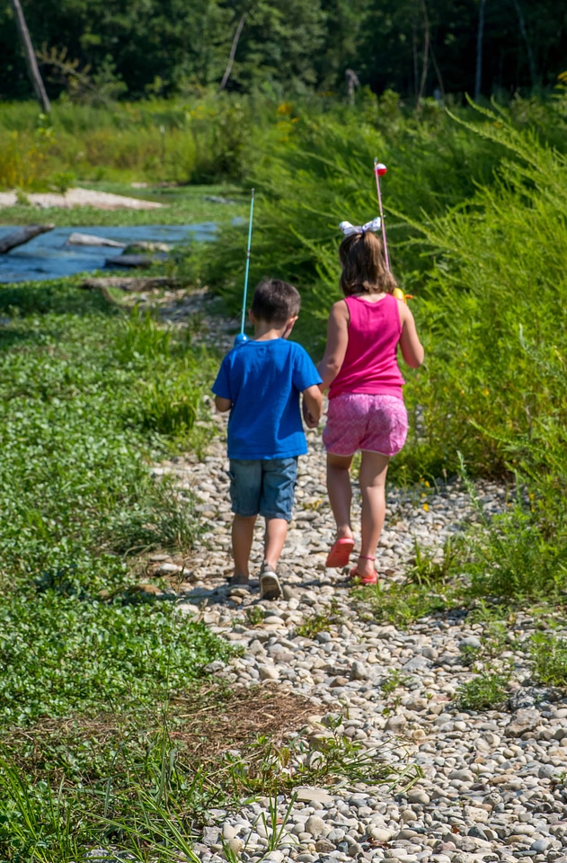 Little boy and girl going fishing, walking along creek-1