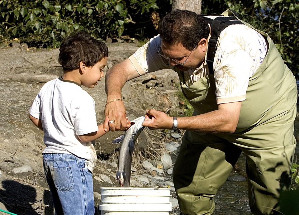 Fisherman teaches a child about fish handling