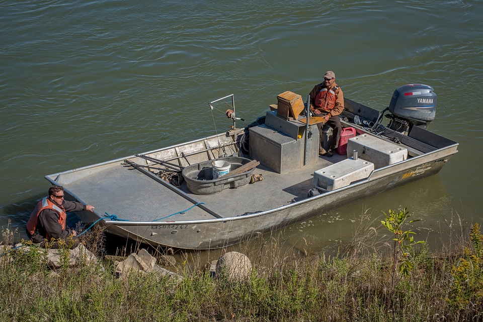 Biologists standing at boat on Missouri River