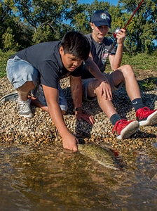 Two boys releasing small mouth bass-1