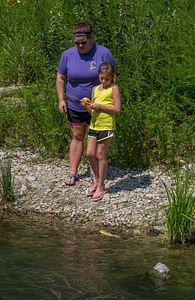Little girl fishing with mother