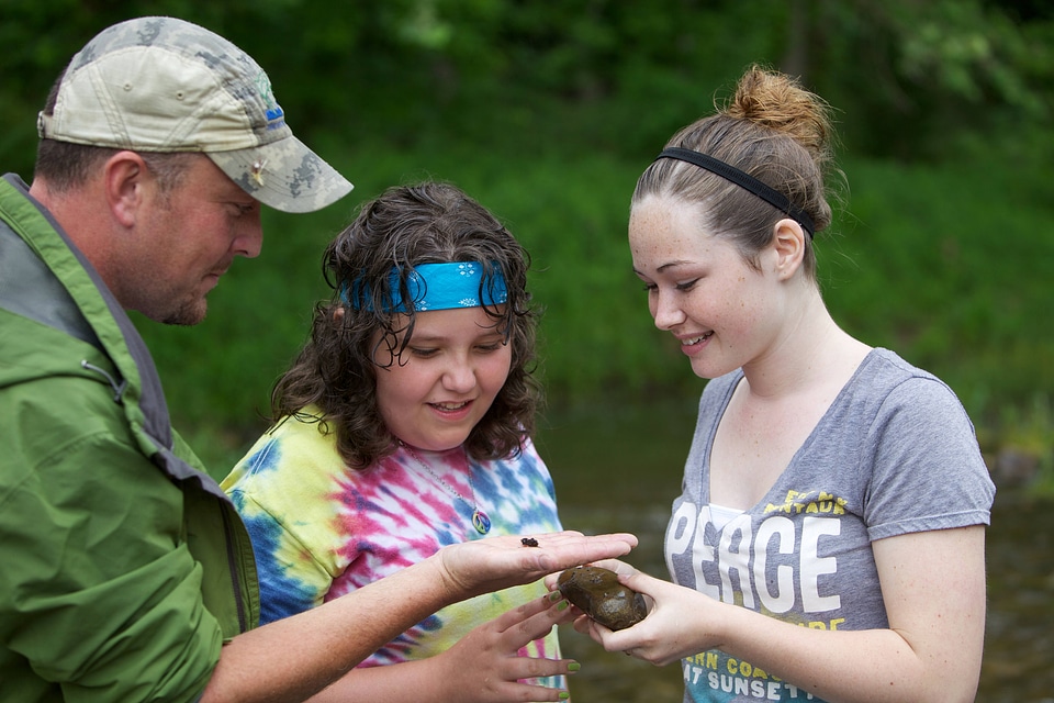 Two teen girls are learning about macroinvertebrates