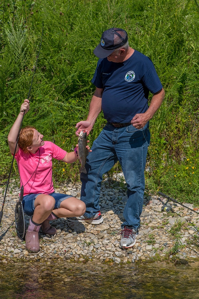 Older man with young redheaded girl and rainbow trout-5