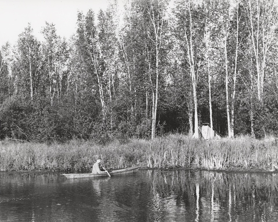 Man in canoe near tent camp