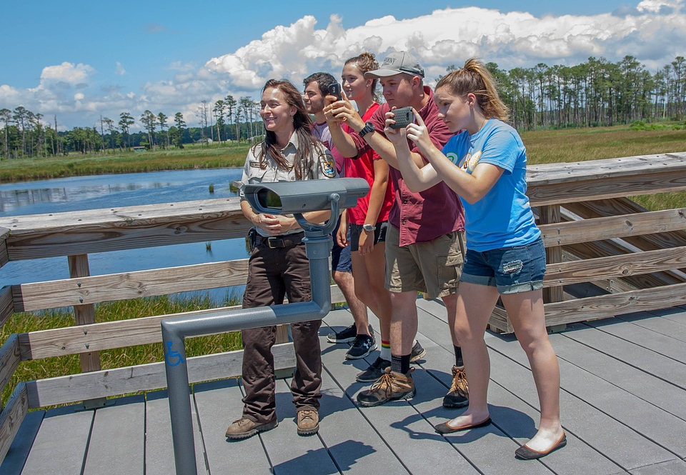 Girl takes cell phone picture of wetland-2