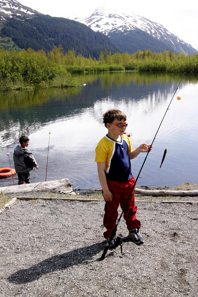 Boy with fishing pole and a small fish photo