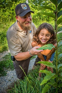 FWS employee shows young girl a Monarch caterpillar-3 photo