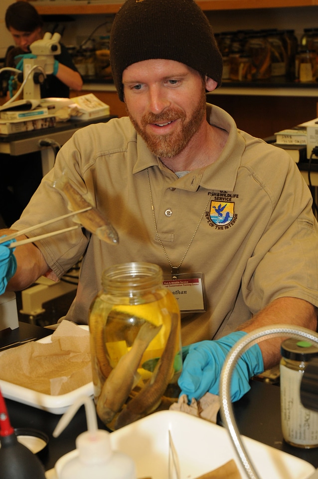 Service employee with jar of specimens