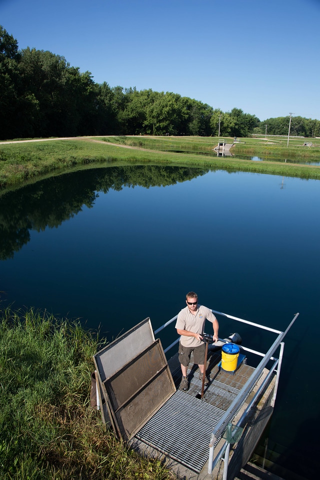 Fishery Biologist adjusts water flow to fish pond-4