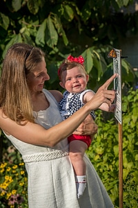 Mother and daughter look at monarch on sign-2