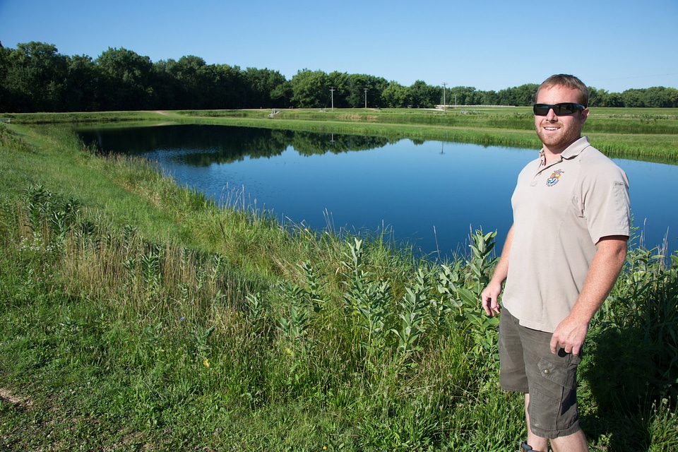 Fishery Biologist adjusts water flow to fish pond-4