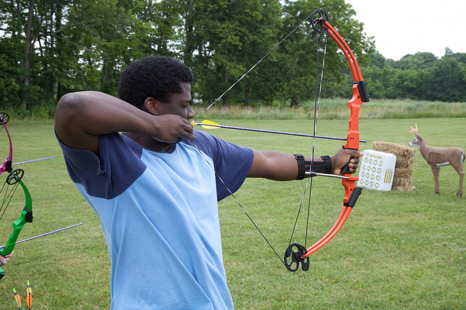 Young man learning archery skills