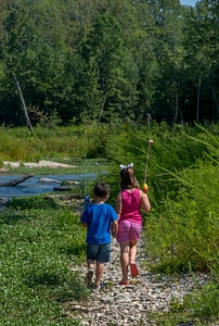 Little boy and girl going fishing, walking along creek-1 photo