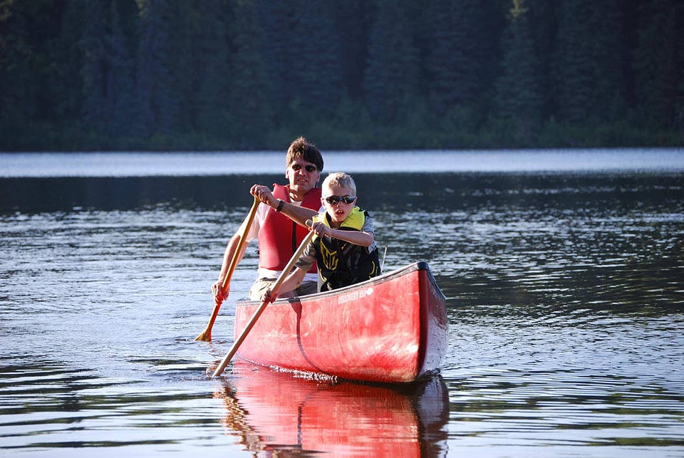 Man and boy paddle a canoe-4