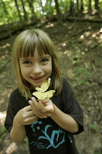 Young girl proudly showing a yellow leaf