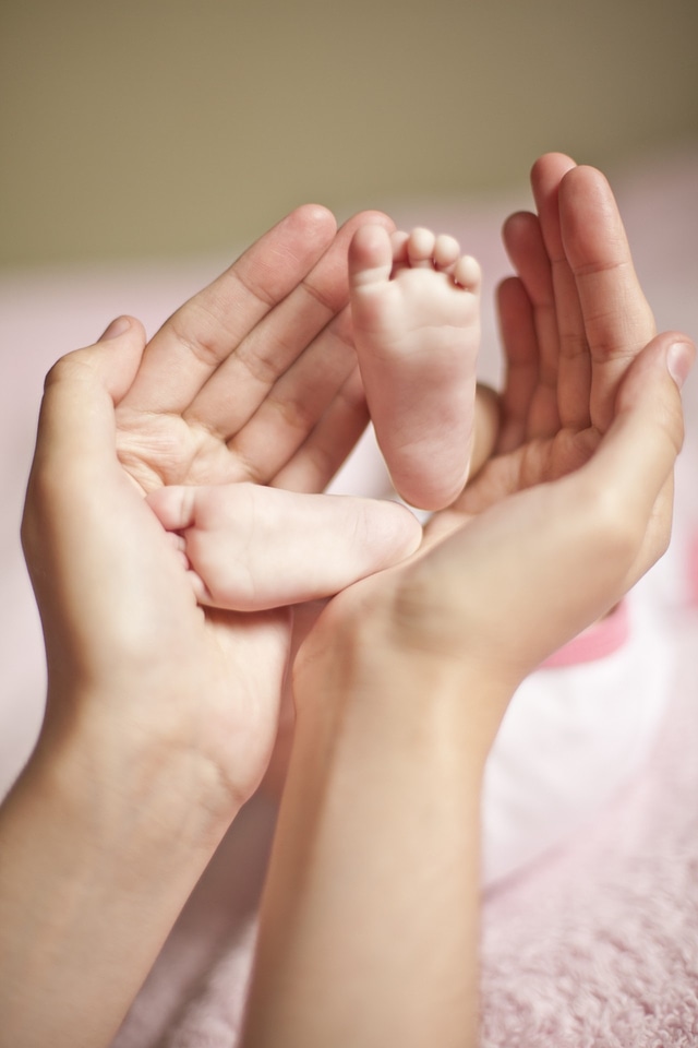 Mother arms baby legs