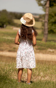 Child in hat looking over the fields photo