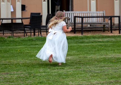 Another bridesmaid running on grass photo