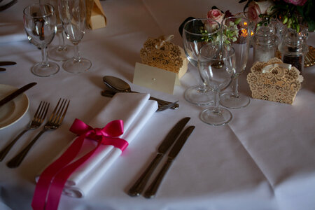 place setting with napkin and pink ribbon photo