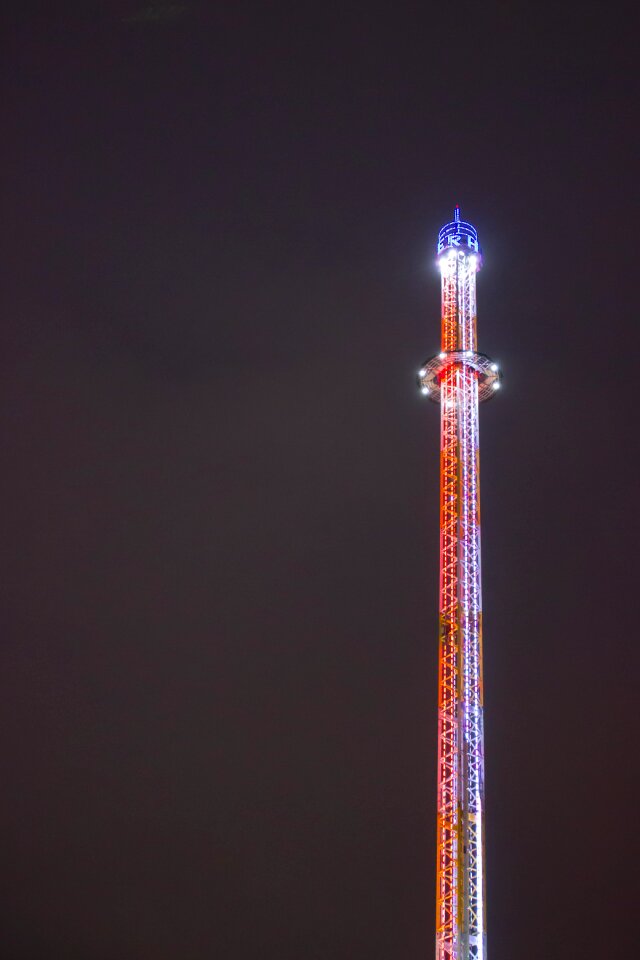 lit funfair tower against dark sky