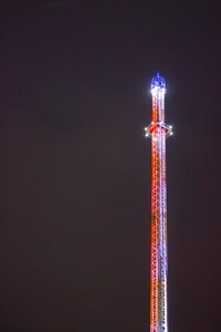 lit funfair tower against dark sky