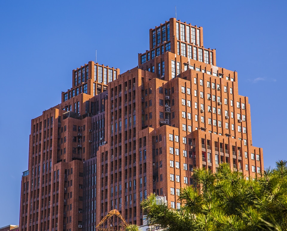 Tall buildings a clear blue sky red house