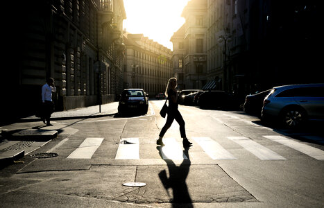 Woman walking a zebra path in the sun