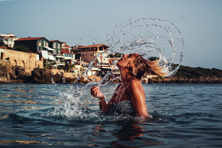 Girl Splashing Hair in the Sea with Mediterranean Background photo