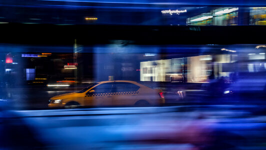 Photo of taxi, taken through bus