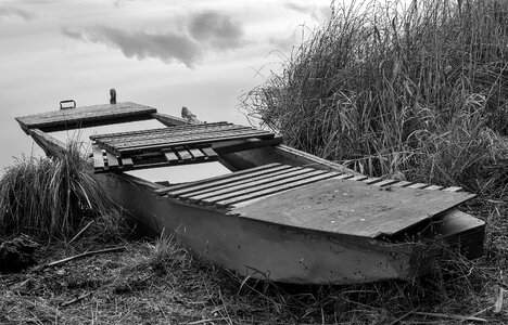 Old wooden punt on the bank of the pond photo