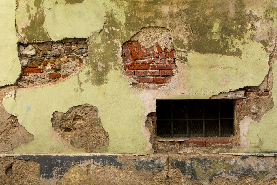 Grungy house facade with cellar window