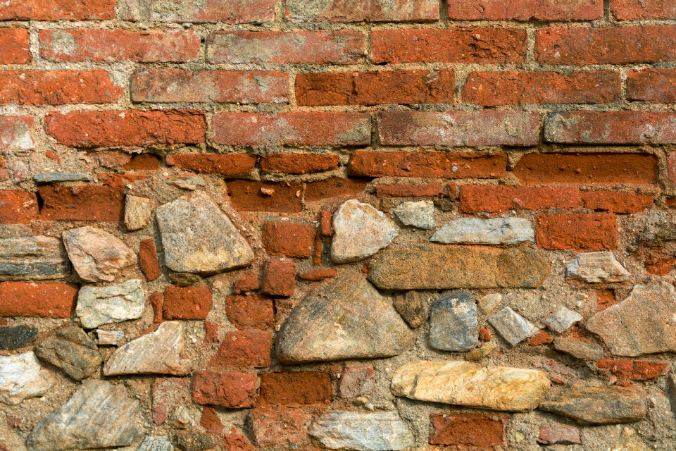 Texture of old wall from orange bricks and stones