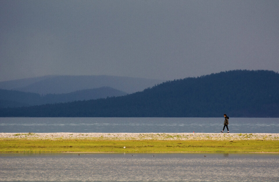 Lonely girl walking by the lake