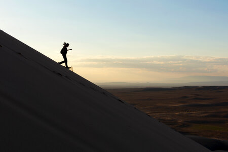A woman runs down the sand dune photo