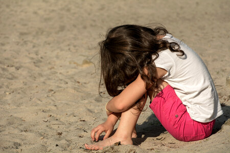 Small sad girl on the beach photo